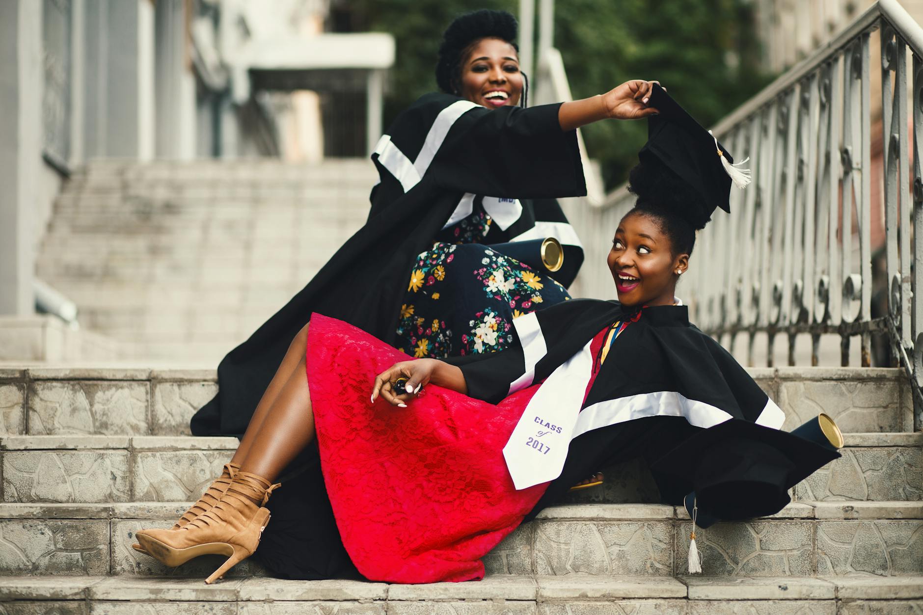 2 female university students all smiles as they graduate from their undergraduate course in the UK