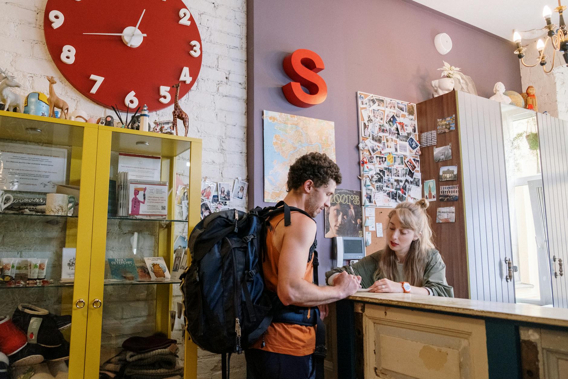 A male student carrying his backpack and speaking to a female education fair officer