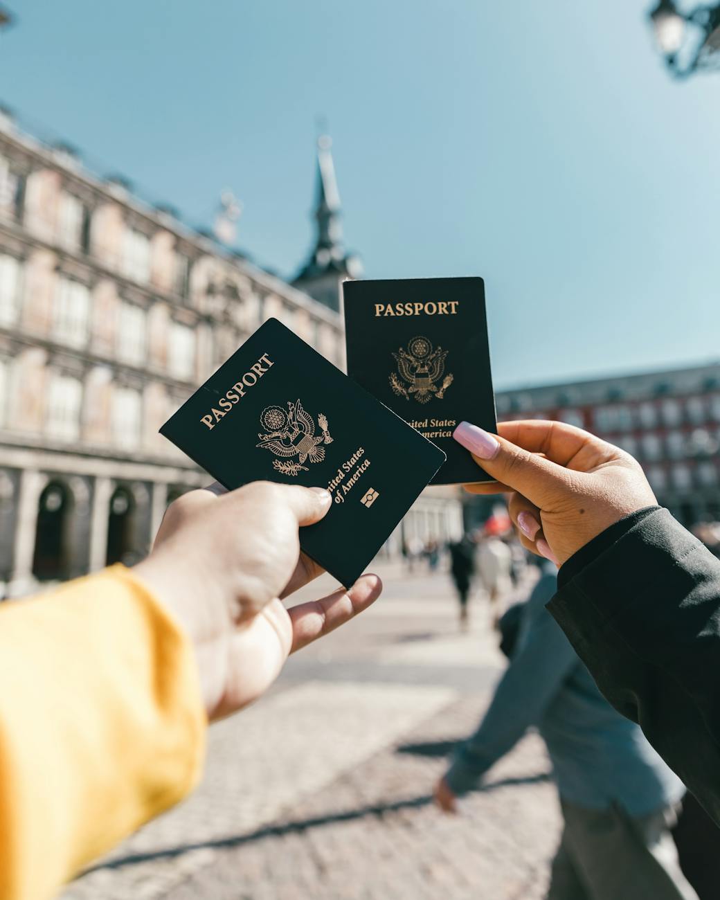 A male and female hand holding the united states passports