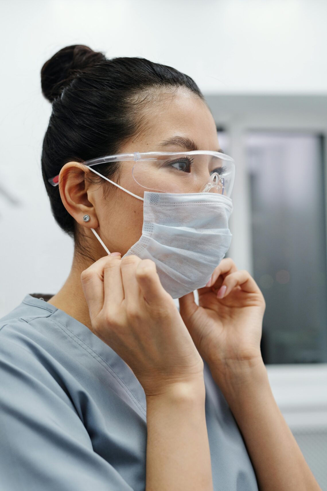 A nurse putting on face mask