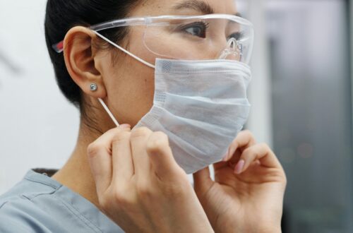 A nurse putting on face mask