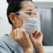 A nurse putting on face mask