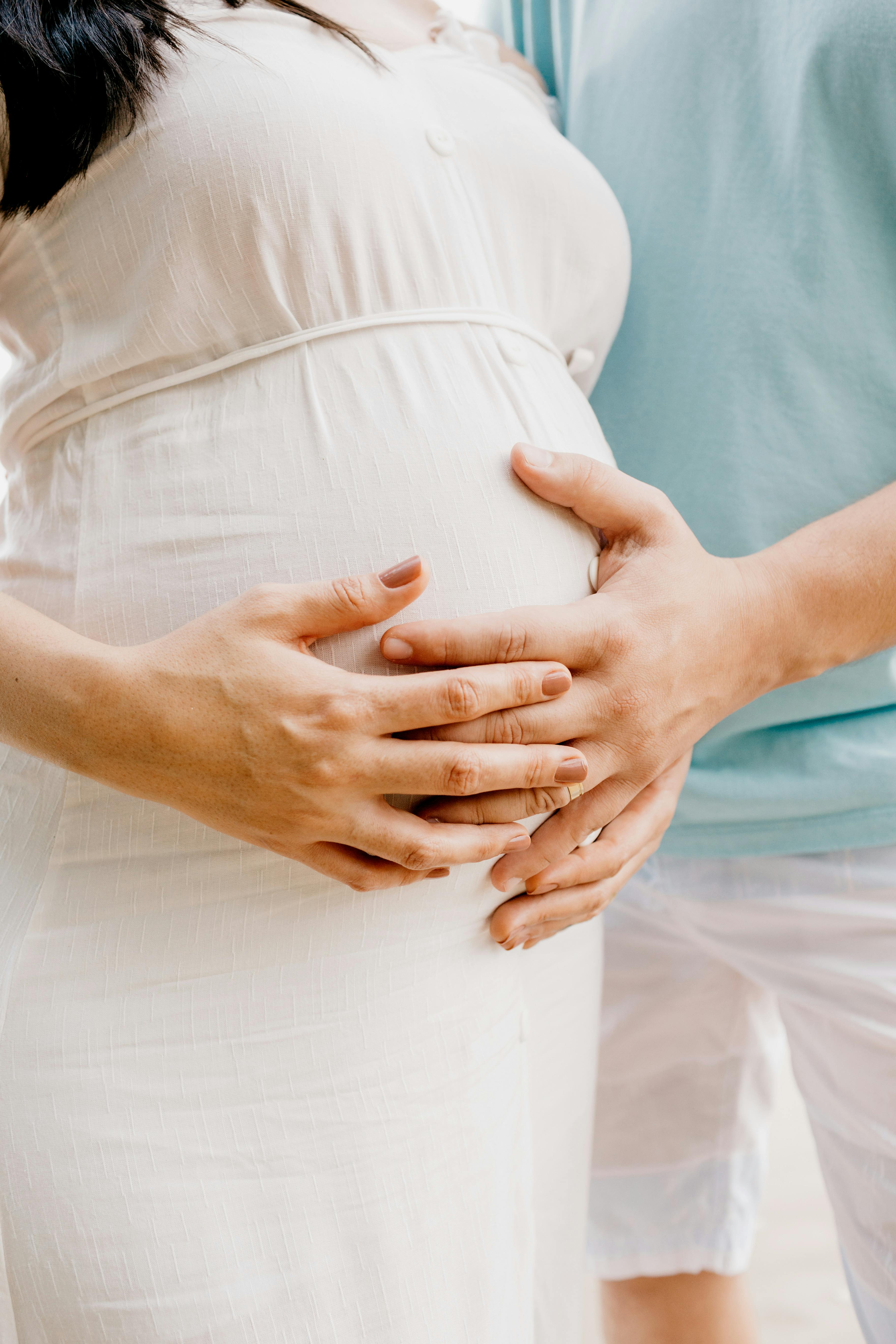 A pregnant woman and her partner rubbing the tummy