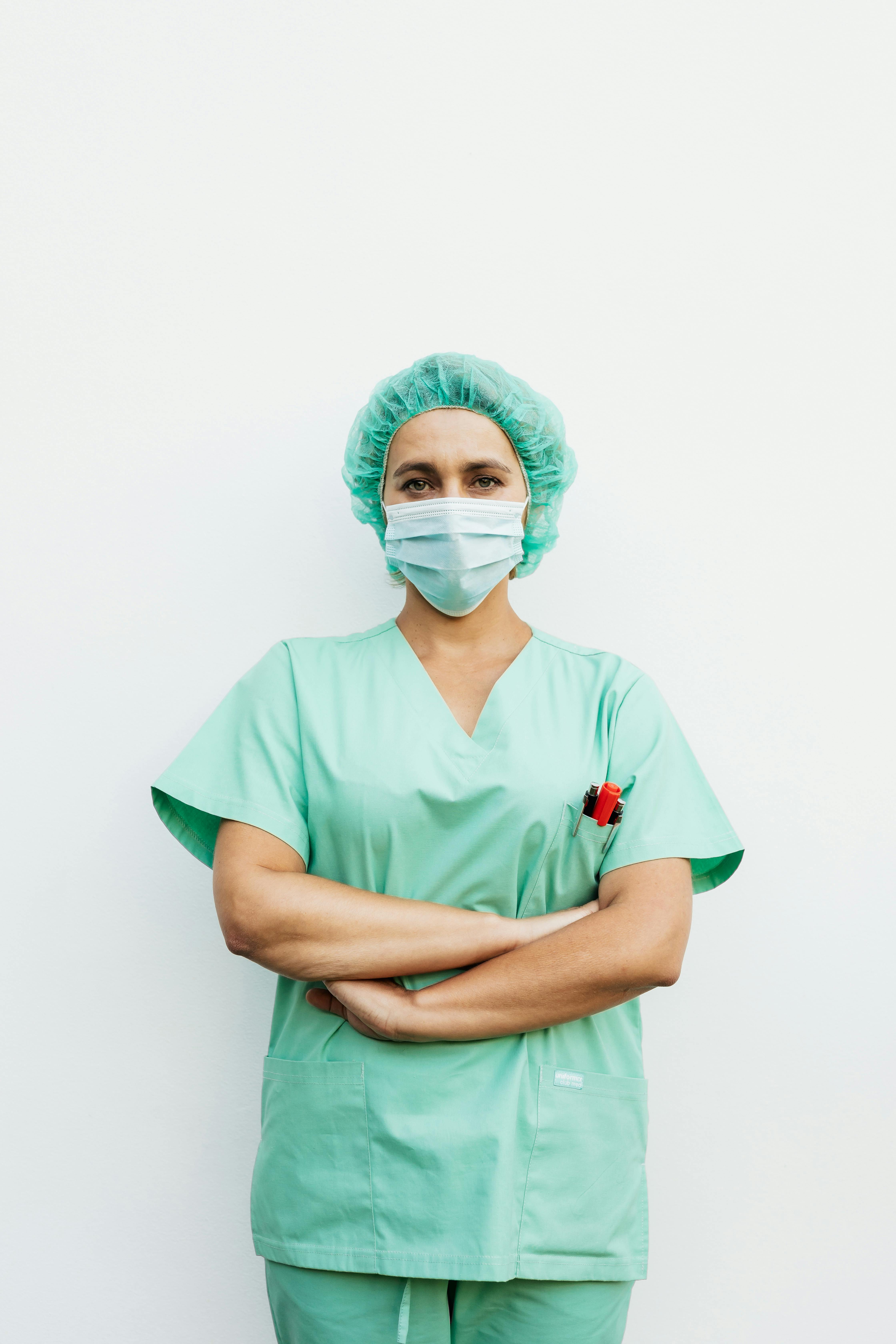 A nurse in green scrubs posing for the camera