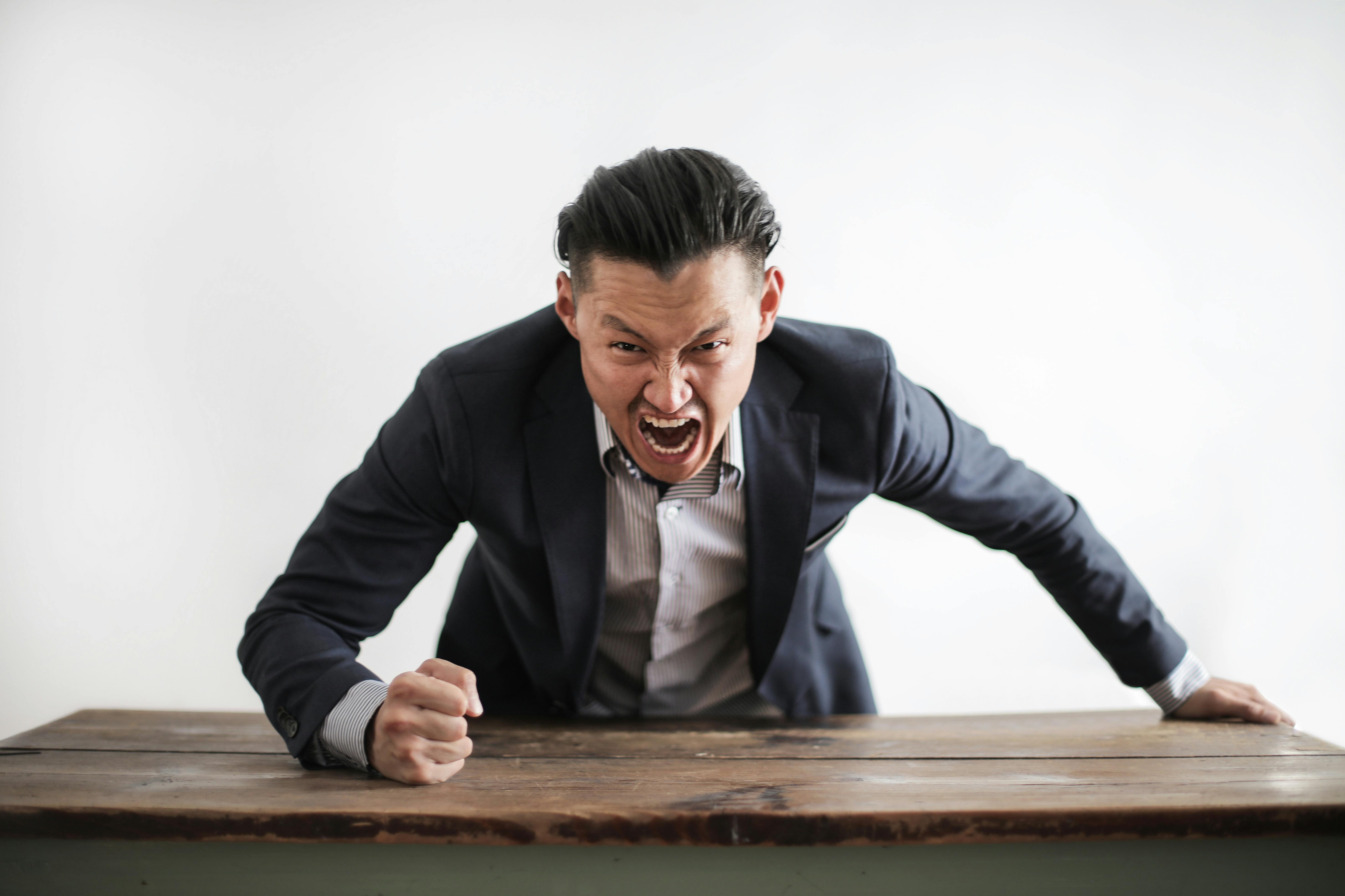 An angry man pounding on the table