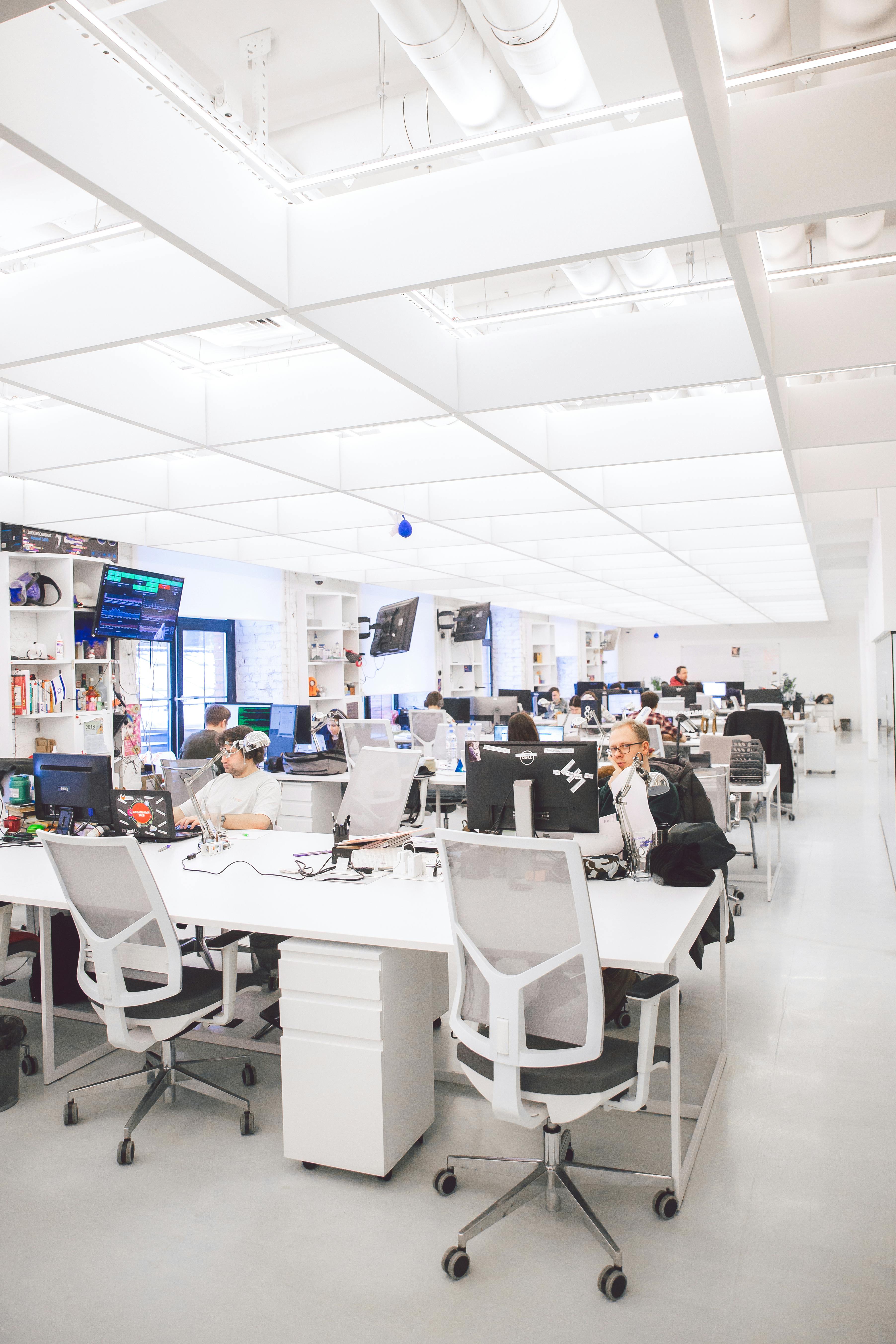 A busy office with many workers in their cubicles.