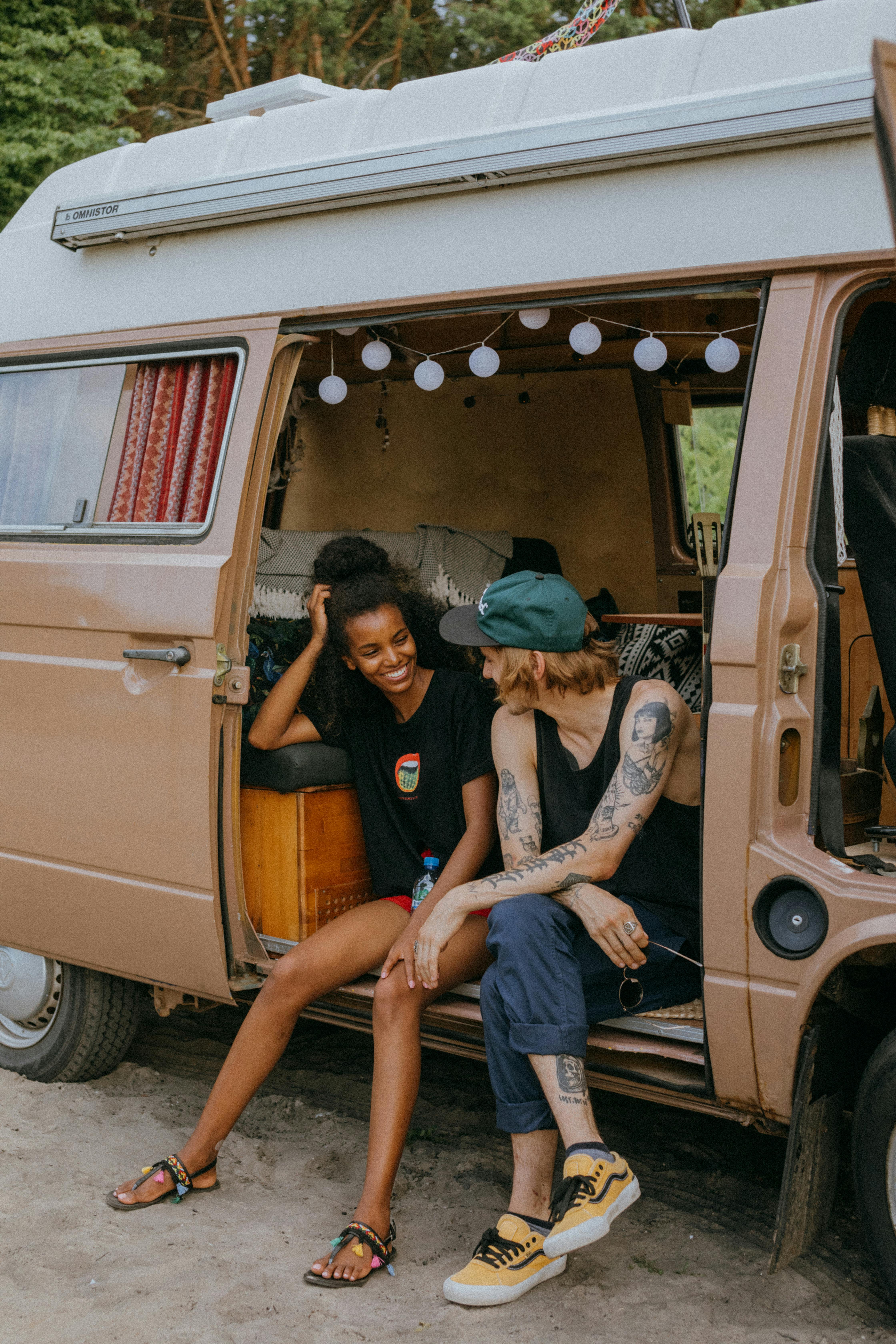 2 friends sitting at the door of their van