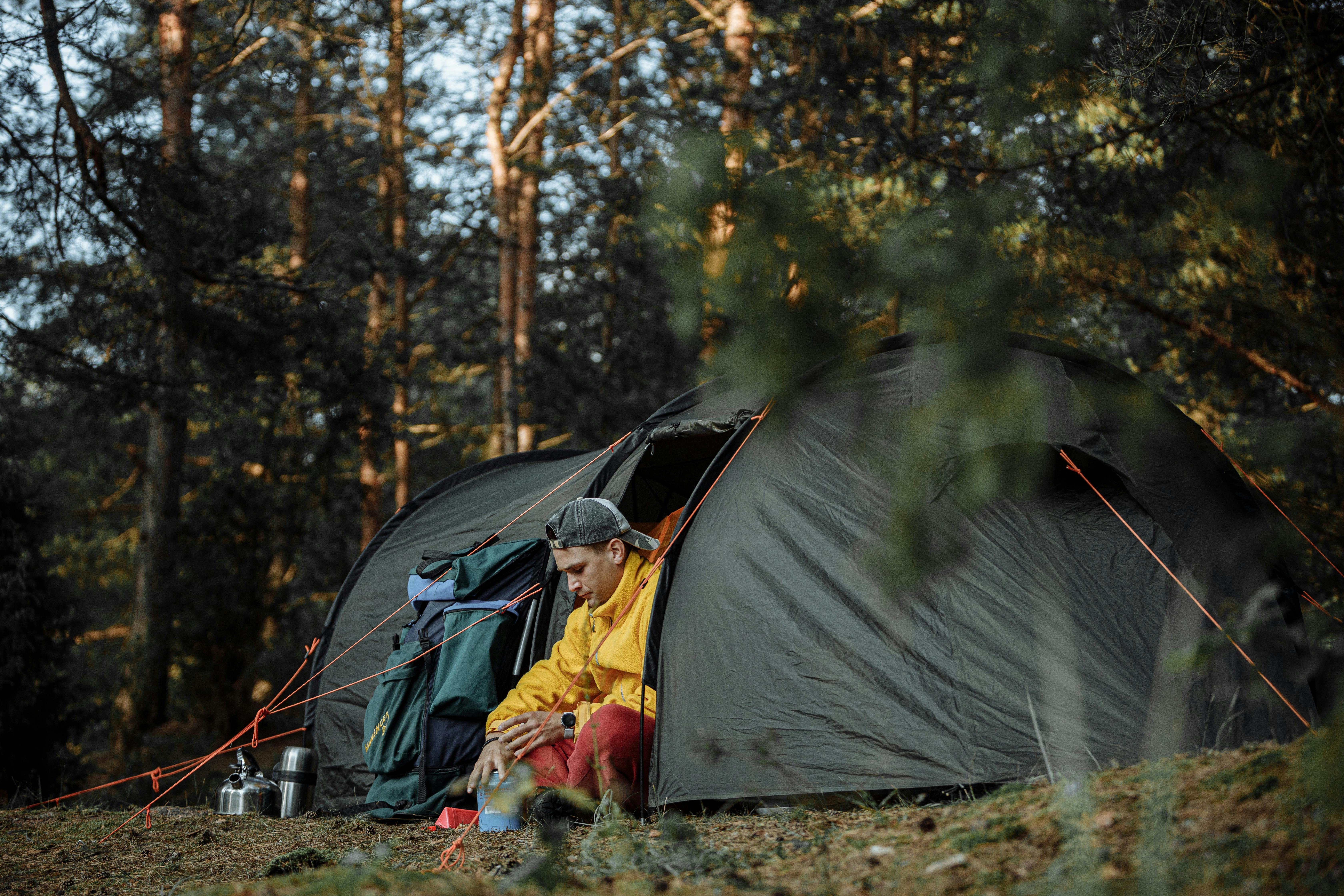 A man sitting at the entrance of his tent