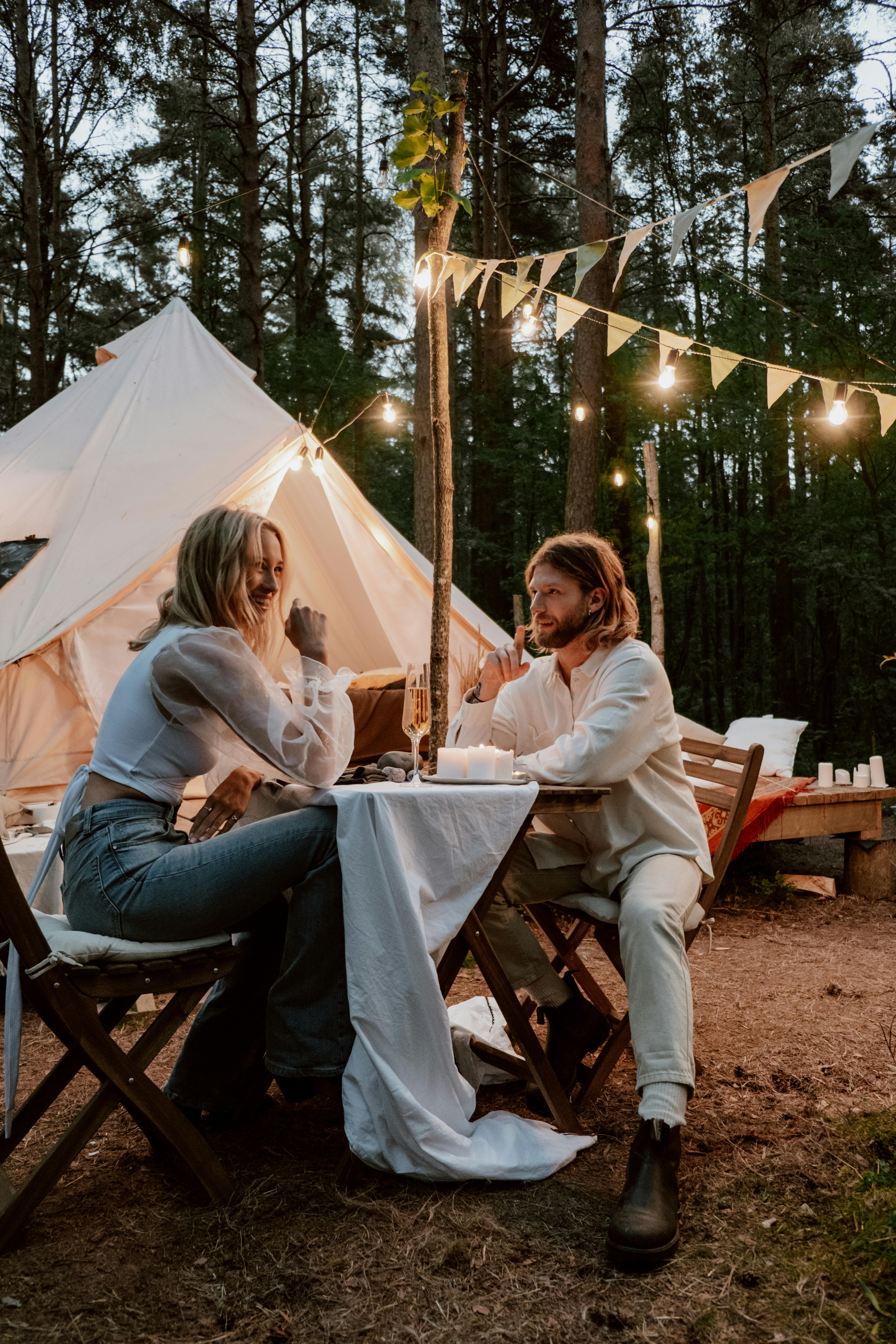 COUPLE EATING A ROMANTIC DINNER WHILE CAMPING