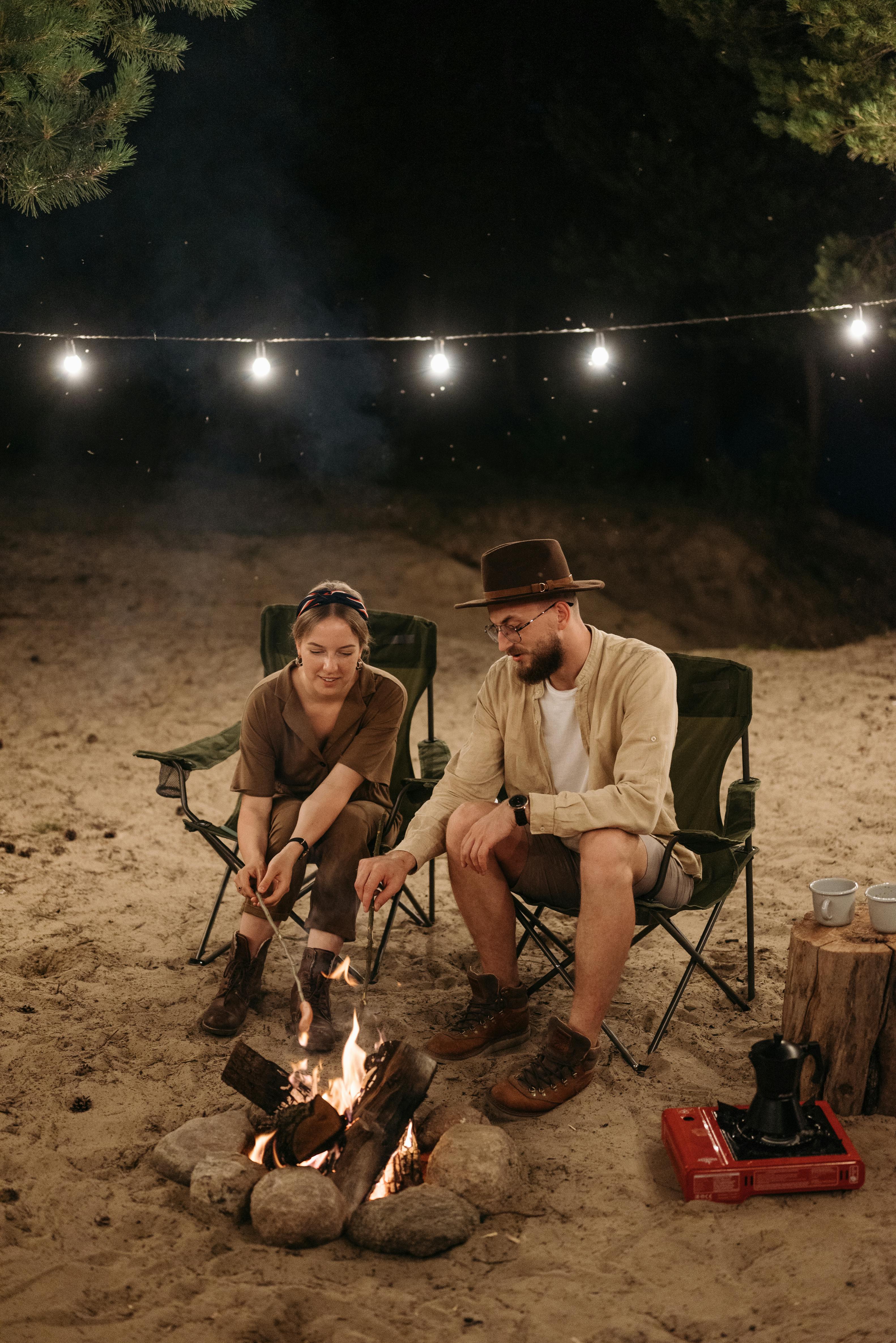 COUPLE ENJOYING CAMPFIRE AT NIGHT