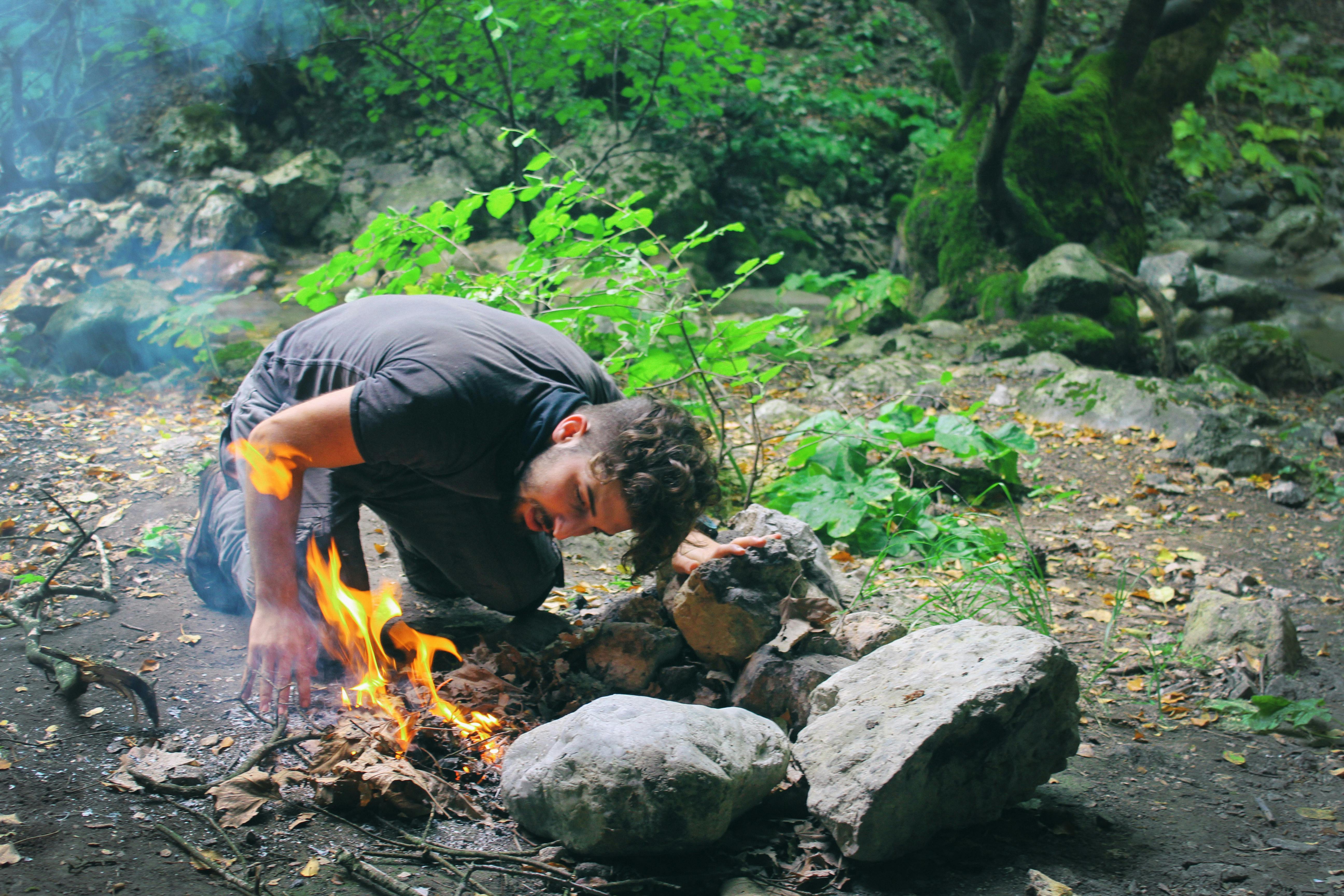 a man fanning camp fire