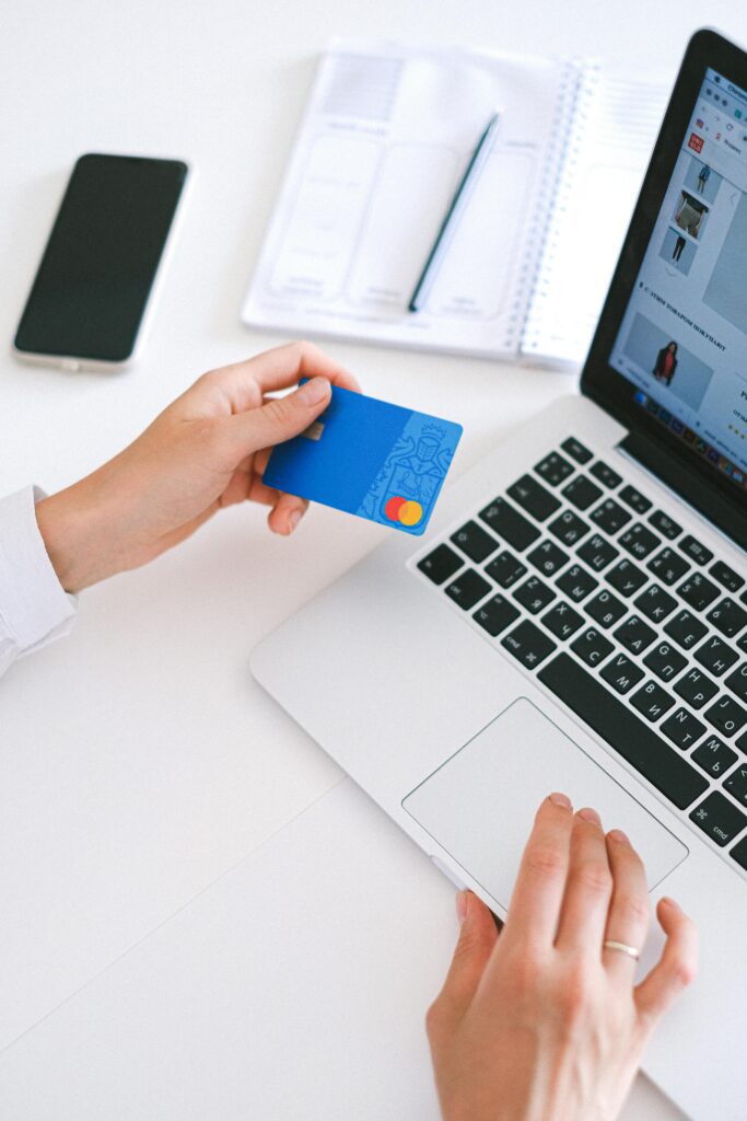 a man holding a mastercard and a laptop